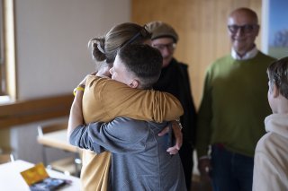 Une collaboratrice de l'association alémanique Tipiti, qui soutient enfants et adolescents dans différents domaines de la vie, embrasse un jeune réfugié ukrainien à Rehetobel (AR). (archives)